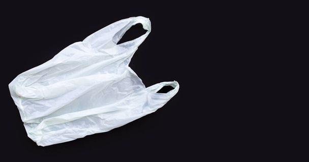 White plastic bag on black background. Copy space - Фото, изображение