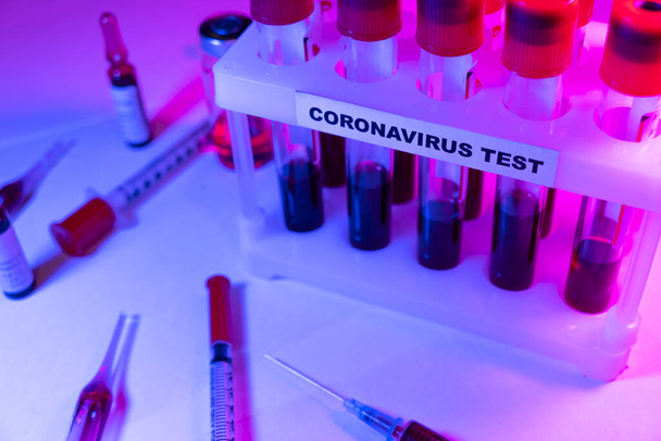 Coronavirus blood test concept. Analyzing blood sample in test tube for coronavirus test. Test tube with blood for 2019-nCoV analyzing. Coronavirus blood analysis concept. - Фото, изображение