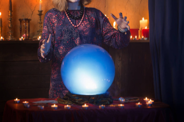 young woman fortune teller with illuminated crystal ball - Valokuva, kuva