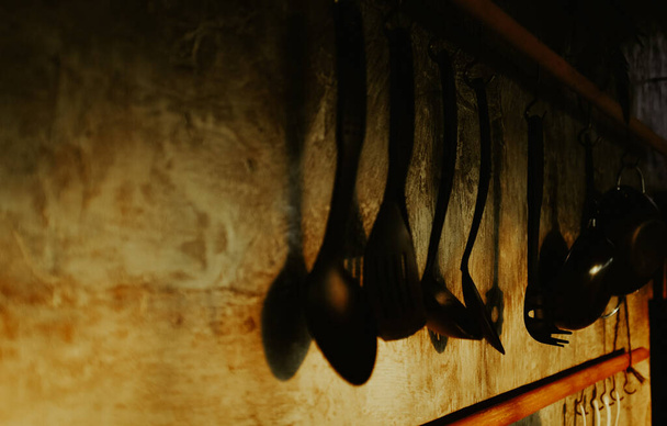 A collection of vintage baking and cooking supplies,hanging on wall under sunlight with dramatic colors. - Photo, Image