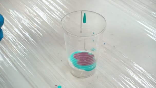 Shooting of acrylic paints in plastic cup - Footage, Video