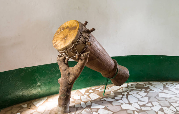 Tambour djembé africain original avec lame en cuir posé sur un tapis roulant formant un tronc en Gambie
 - Photo, image