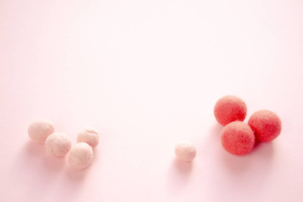 Montón de bolas de lana de fieltro en la parte superior de la superficie manchada de rosa. Hecho a mano para pasatiempos o perlas para joyas o accesorios. - Foto, Imagen