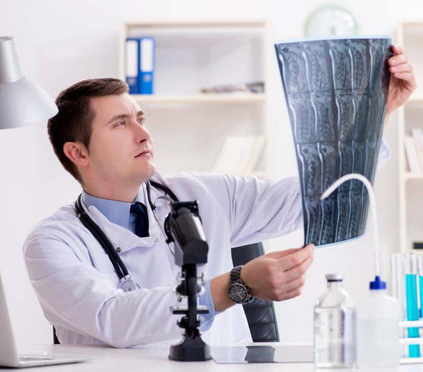 Médico varón mirando los resultados de laboratorio en el hospital - Foto, imagen