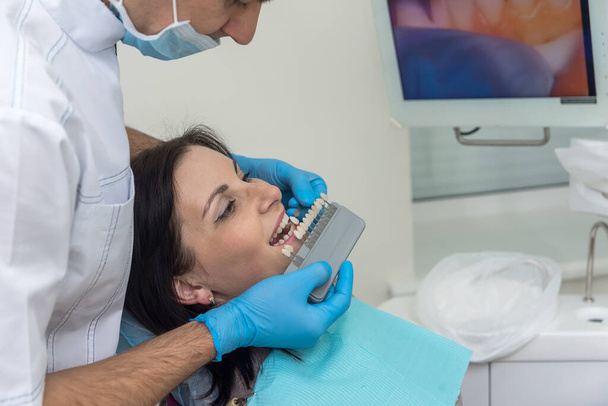 Hammaslääkäri vertaamalla potilaan hampaat kruunu näytteenotin
 - Valokuva, kuva