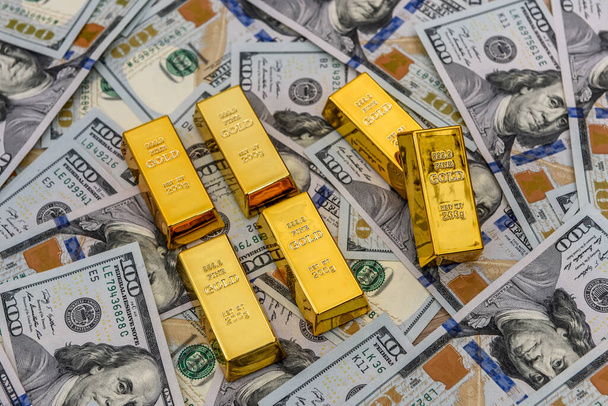 Miliarda zlata v řadě na pozadí dolarů - Fotografie, Obrázek