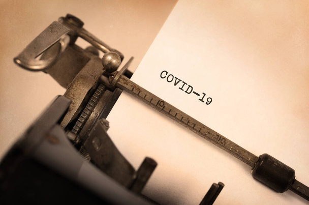 Máquina de escribir vintage con un mensaje escrito; COVID-19
 - Foto, imagen