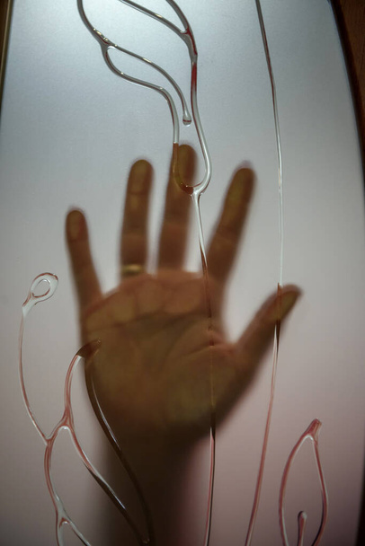Mano umana dietro vetro smerigliato porta, da vicino
 - Foto, immagini