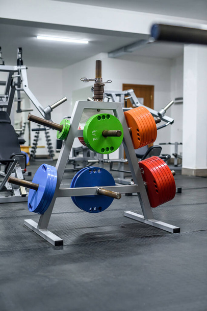 Coloridos pesos en gimnasio para entrenar con barra de pesas
 - Foto, imagen