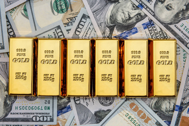 Χρυσές ράβδοι σε τραπεζογραμμάτια αμερικανικού δολαρίου κλείνουν - Φωτογραφία, εικόνα