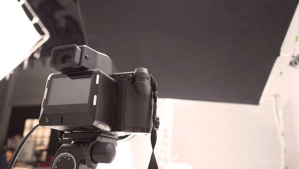 Configuración de cámara digital de formato medio de estudio en trípode y equipo profesional en estudio con softbox de color blanco y negro y set de iluminación para rodaje de fotos fijas o trabajos de video o película de alta resolución
 - Foto, Imagen