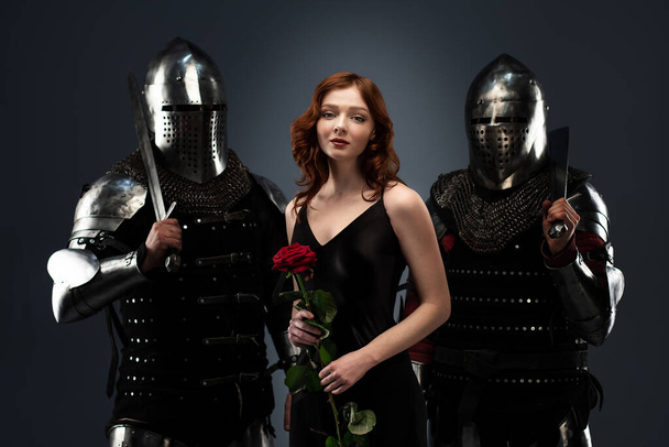 Красивая девушка в черном платье и рыцари в доспехах
 - Фото, изображение