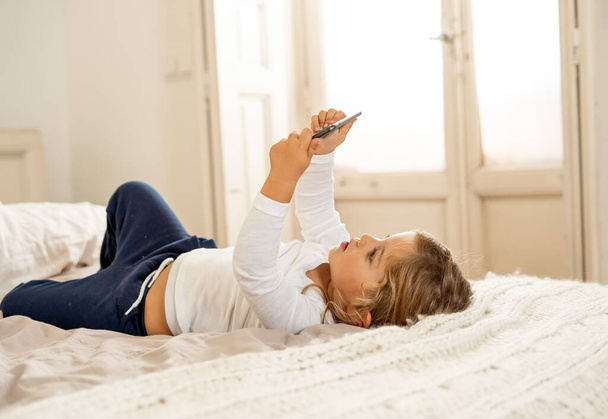 Little caucasian girl on mobile phone playing, watching cartoons or chatting with family. Cute blonde toddler using smart phone In Education and technology, digital generation and phone addiction. - Fotoğraf, Görsel