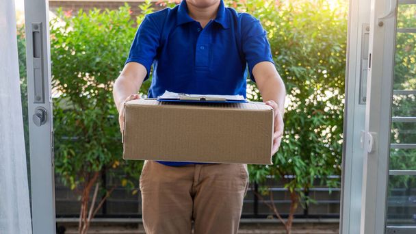 宅配便業者は、宅配ボックスを受け入れるために顧客に配達するために段ボール小包パッケージを確認または保持 - 写真・画像