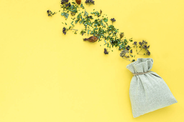 kruidenthee, droge planten en bloemen, oregano en munt vitamine drank in een linnen zak, isoleren, plaats voor tekst, kopieer ruimte. - Foto, afbeelding