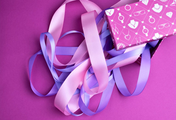 Coffret cadeau avec rubans roses et violets, sur fond violet, vue de dessus
 - Photo, image