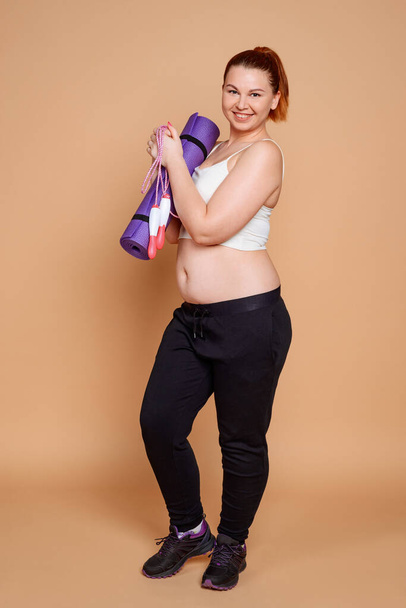 Corpulent woman taking fitness classes to make her body fit - 写真・画像