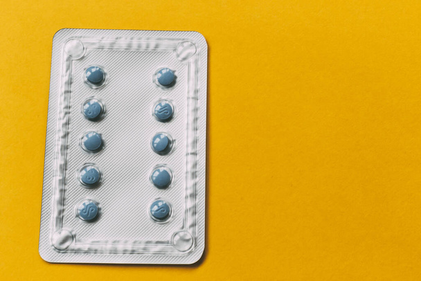 blue medicine blister pack on yellow background. medical concept - 写真・画像