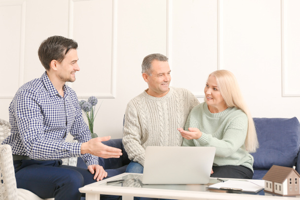 Male real estate agent working with mature couple indoors - Fotoğraf, Görsel