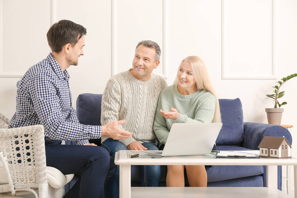 Male real estate agent working with mature couple indoors - Foto, Imagem