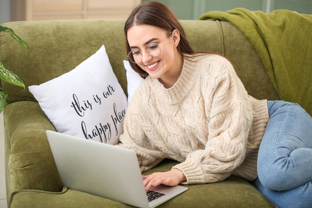 Mujer joven con gafas con estilo utilizando el ordenador portátil en casa
 - Foto, Imagen