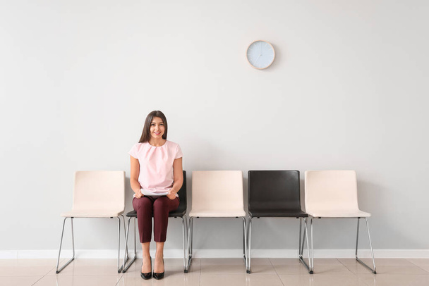 Nuori nainen odottaa työhaastattelua sisätiloissa
 - Valokuva, kuva