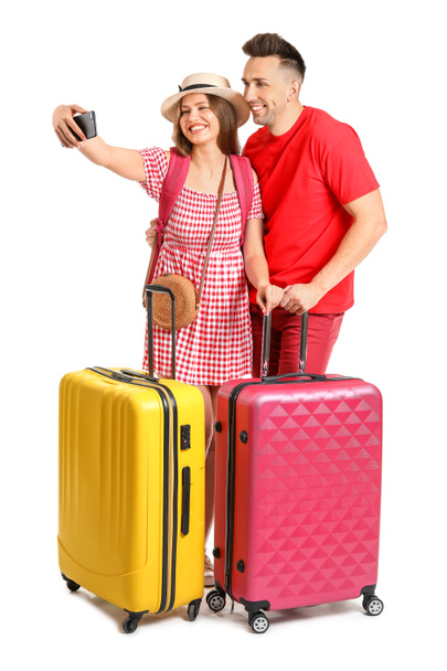 Couple of tourists with luggage taking selfie on white background - Photo, Image