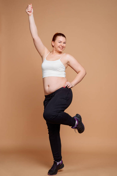 Cheerful woman doing stretch exercises for weight loss - Foto, afbeelding