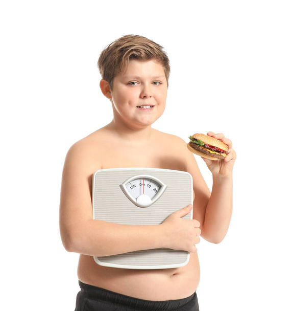 Υπέρβαρο αγόρι με burger και κλίμακες σε λευκό φόντο - Φωτογραφία, εικόνα