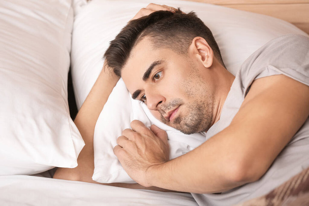 Depressed young man in bedroom - Foto, Bild