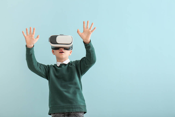 Little boy with virtual reality glasses on color background - Foto, Imagem