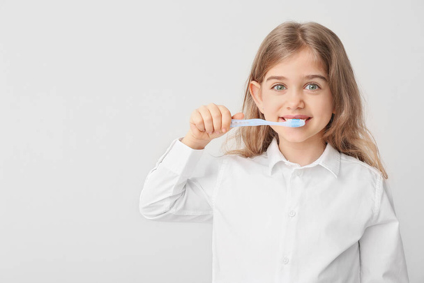 Cute little girl with toothbrush on white background - Foto, Imagen