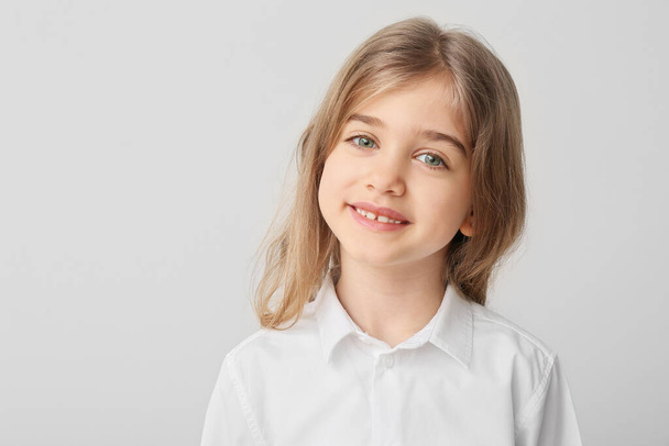 Счастливая маленькая девочка со здоровыми зубами на светлом фоне
 - Фото, изображение
