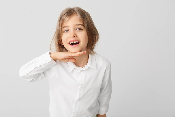 gelukkig klein meisje met gezonde tanden op lichte achtergrond - Foto, afbeelding