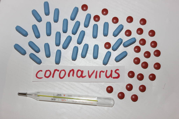 Coronavirus inscription among pills. Coronavirus treatment. Coronovirus causes fever - Photo, Image