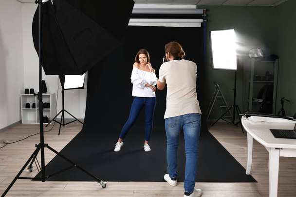 Professional photographer working with model in studio - Fotó, kép