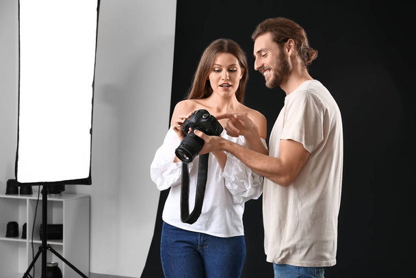 Fotógrafo profesional mostrando fotos a modelo en estudio
 - Foto, imagen