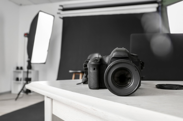 Modern camera on table in professional photo studio - Photo, image