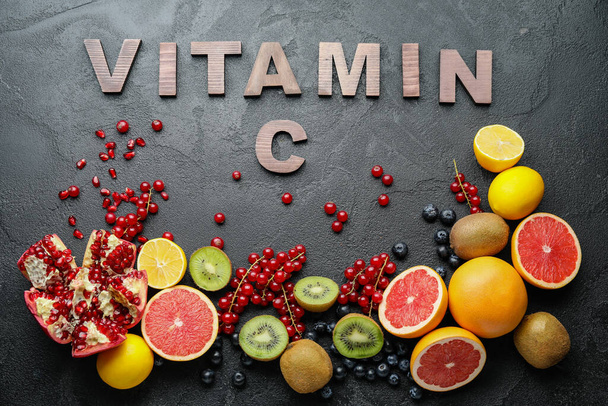 Produits sains riches en vitamine C sur fond sombre - Photo, image