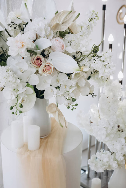 Vertikální obrazy krásných dekorativních růžových růží a bílých květin. Letní květinová kompozice na prázdninovém stole. Elegantní aranžmá květinářství nastavení. Svatební party dekorace detail - Fotografie, Obrázek