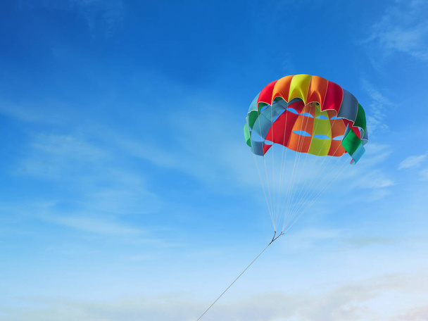 As listras de paraquedas coloridas no céu, acampamento de verão na praia
 - Foto, Imagem