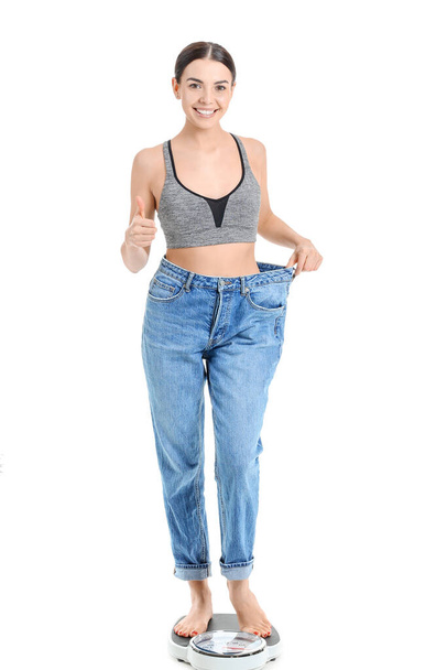Young woman in loose clothes on white background. Weight loss concept - Valokuva, kuva