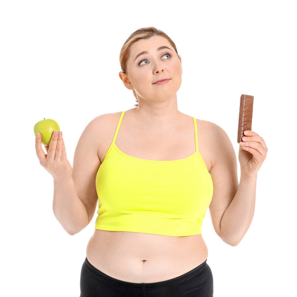 Overweight woman with healthy and unhealthy food on white background. Weight loss concept - Фото, изображение