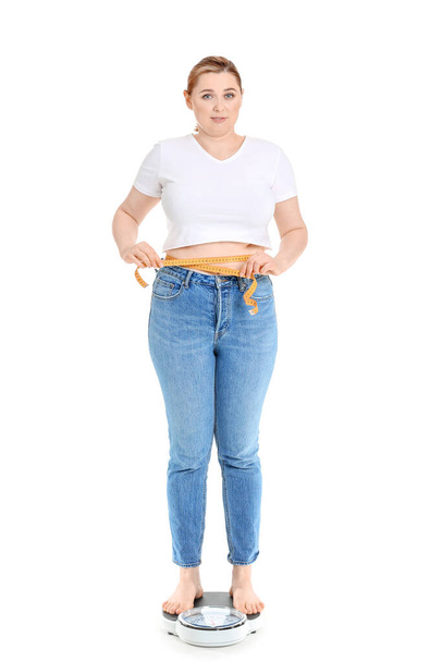 Overweight woman on scales against white background. Weight loss concept - Foto, immagini