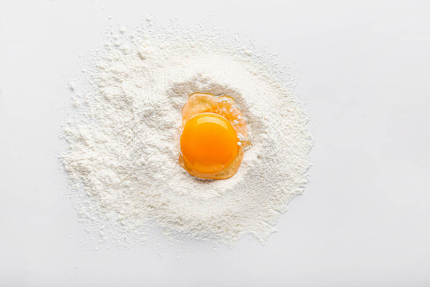 Raw chicken egg and flour on white background - Zdjęcie, obraz