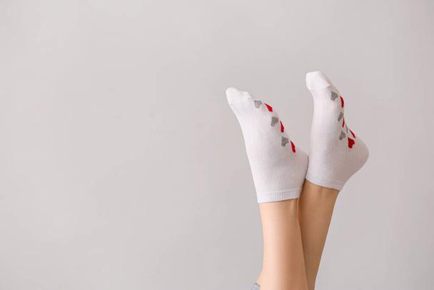 benen van vrouw in sokken op grijze achtergrond - Foto, afbeelding