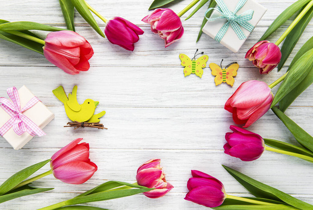 春のチューリップの花やギフトボックスは、フラットレイアウトスタイルで上から古い白いテーブルの上に。女性や母の日への挨拶. - 写真・画像
