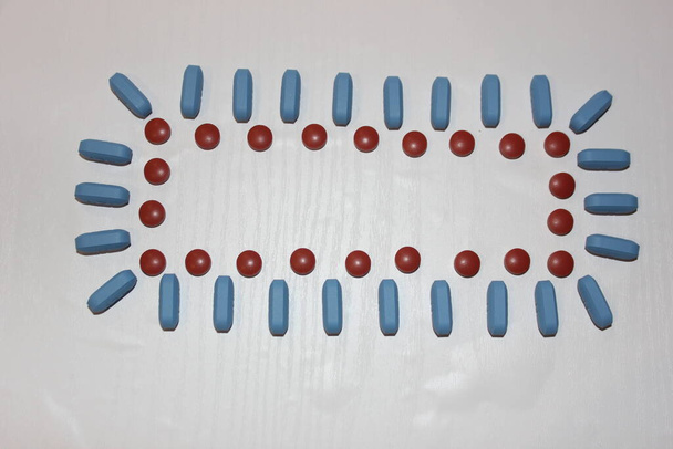 Conceito de medicina. Quadro de pílulas com espaço de cópia para uma inscrição no meio em uma mesa branca
 - Foto, Imagem