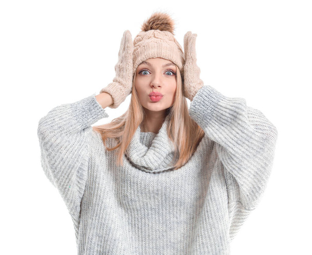 Young woman in warm sweater, hat and gloves on white background - Fotó, kép