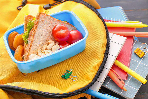 Almuerzo escolar y mochila sobre fondo de madera
 - Foto, Imagen